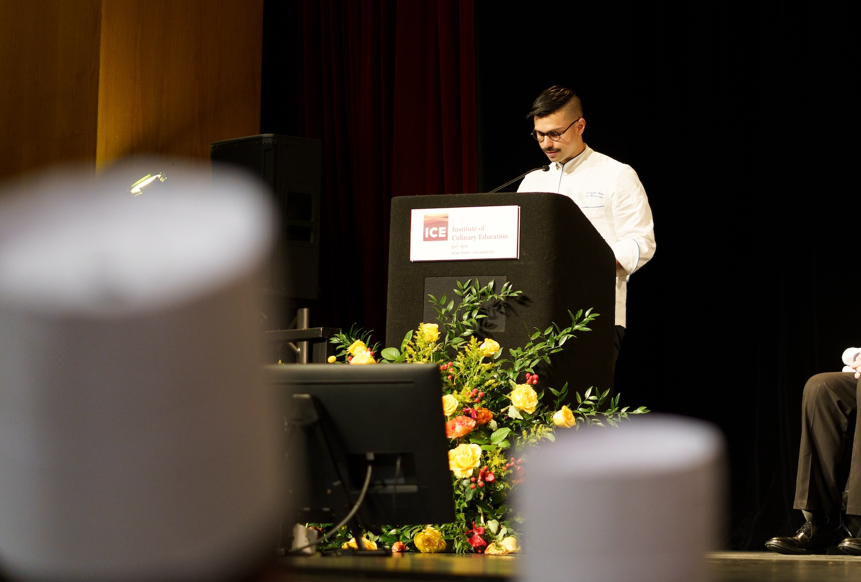 ICE graduate Orlando Soto speaks at a podium at ICE New York's 2023 commencement ceremony